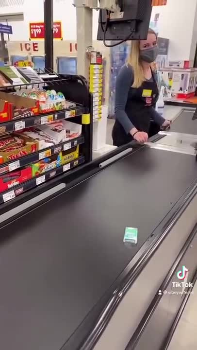 Cashier is waiting on tictacs to go all the way down the conveyor belt.