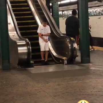 A little boy in white bottom of opposite escalator