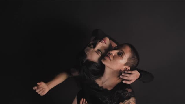 Women dancing together on a dark background