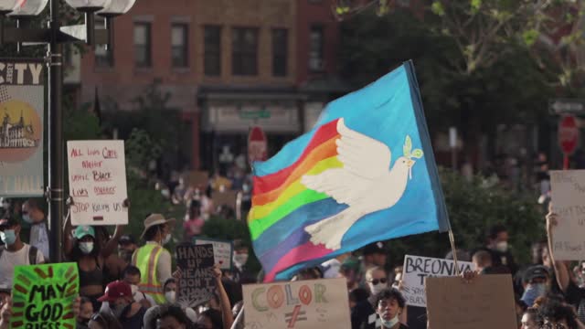 A Cwowd Of People Demonstrating In The Street