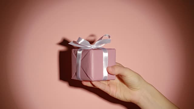 Hand Holding a Gift in the Spotlight