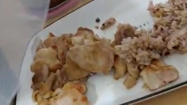 A cat caught trying to steal a chicken.