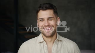 Young Man Smiling And Laughing, Looking At Camera Indoors
