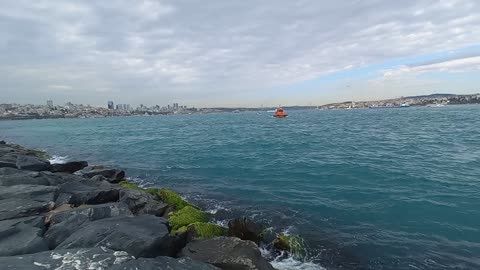 Beautiful sea waves on the rocky shore and wonderful clouds