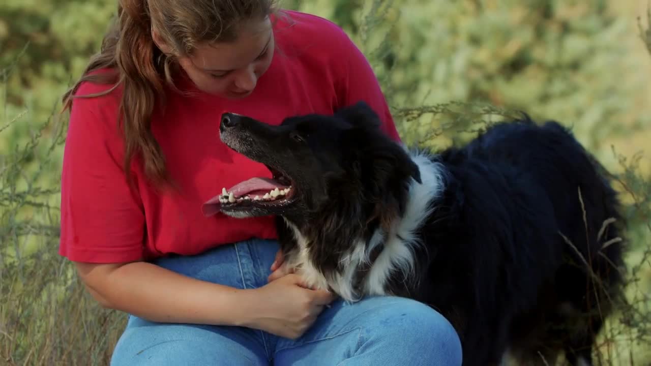 Plump woman and her cute black dog outdoors together