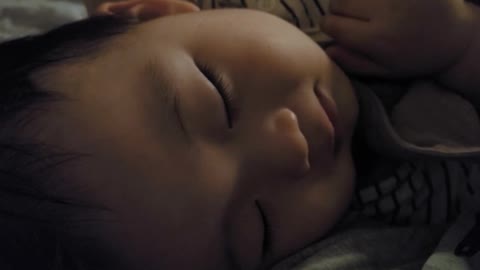 A baby laughing while sleeping