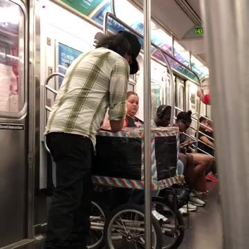 Guy performing magic out of small stroller box on subway
