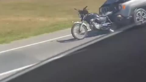 man drags motorcycle stuck in front of the race without him realizing it