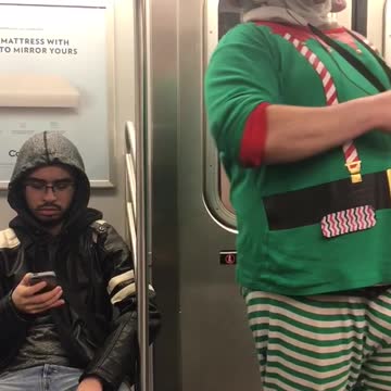 Man in elf outfit on subway train