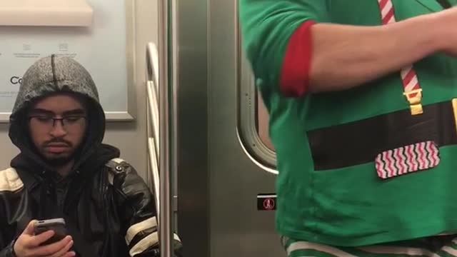 Man in elf outfit on subway train