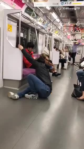 Guy tries to do back flip off of subway handle bars falls to ground