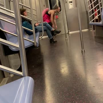 Drunk man with pink cowboy hat costume spins on subway