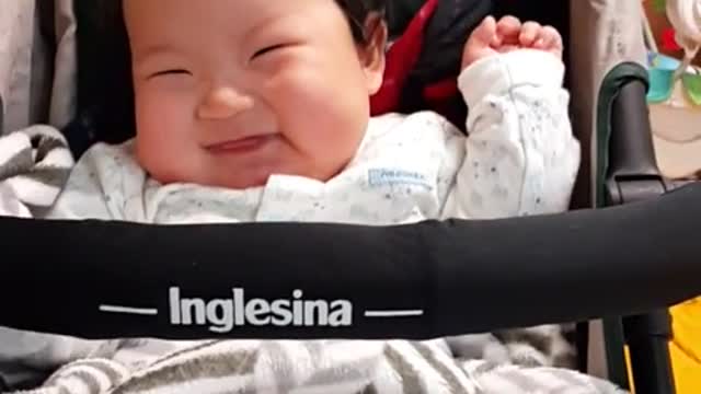 This is a video of a baby smiling brightly while playing with his father.