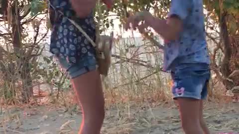 Children dance on the beach near Barbara Streisand