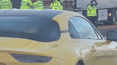 Police Escort People Out of Truck's Trailer