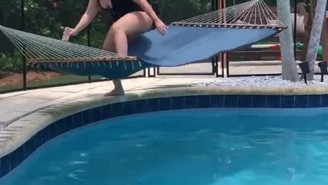 Woman Trying to Relax Flips in Poolside Hammock