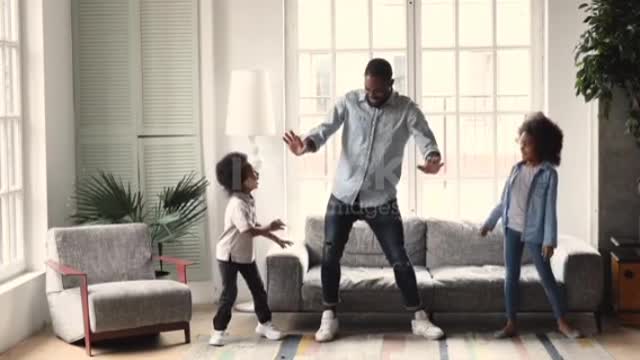 African dad dancing having fun with kids in living room ❤️