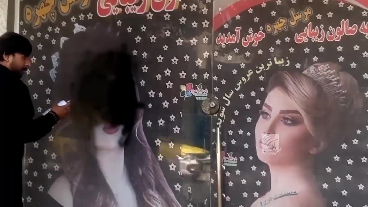 Beauty salon staff in Kabul paint over the images of women