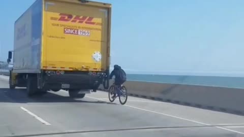 biker holds on to truck across richmond bridge bay area