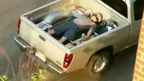 Man sleeping in bed of truck