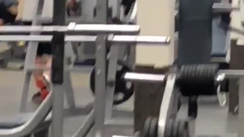 Man in black shorts legs up at gym