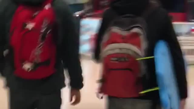 Guy carries surfboard through a mall