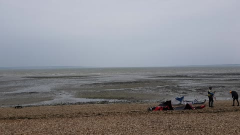 KITE SURFERS . getting ready to go into the water.