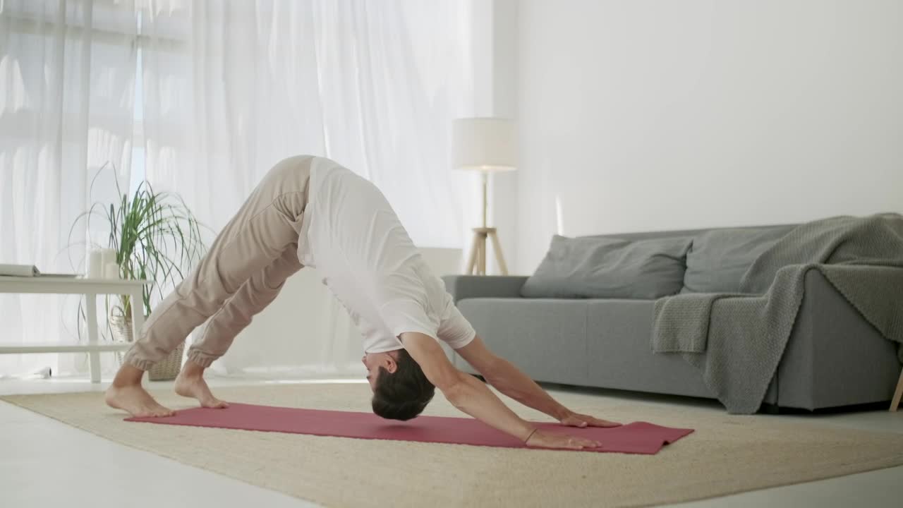 Young man doing yoga routine at home in living room