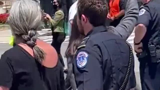 AOC pretends to be handcuffed outside of the United States Supreme Court while protesting the Dobbs decision.