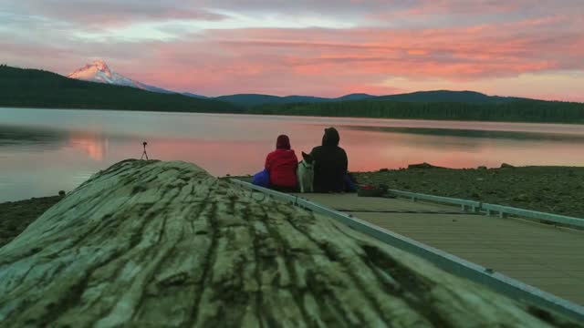 Couple with a Cute Dog enjoying Peaceful Panoramic Mountain Lake View