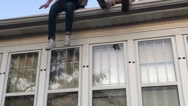 Guy jumps off small roof legs collapse