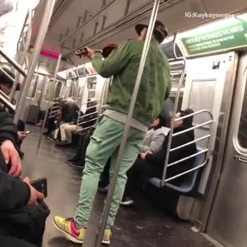Green jacket and hat guy plays violin on the subway car