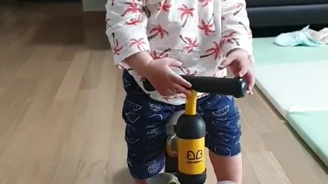 This is a video of a baby riding a toy bike.