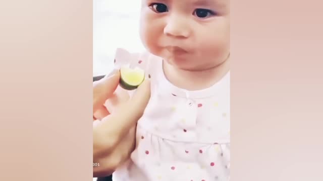 The baby 👶 eat lemon 🍋. Or she giving a cute face expression.