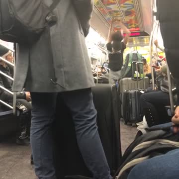 Subway performer spins upside down on handrails and dances