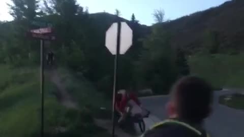 Guy thows football at mountain biker and he falls into street