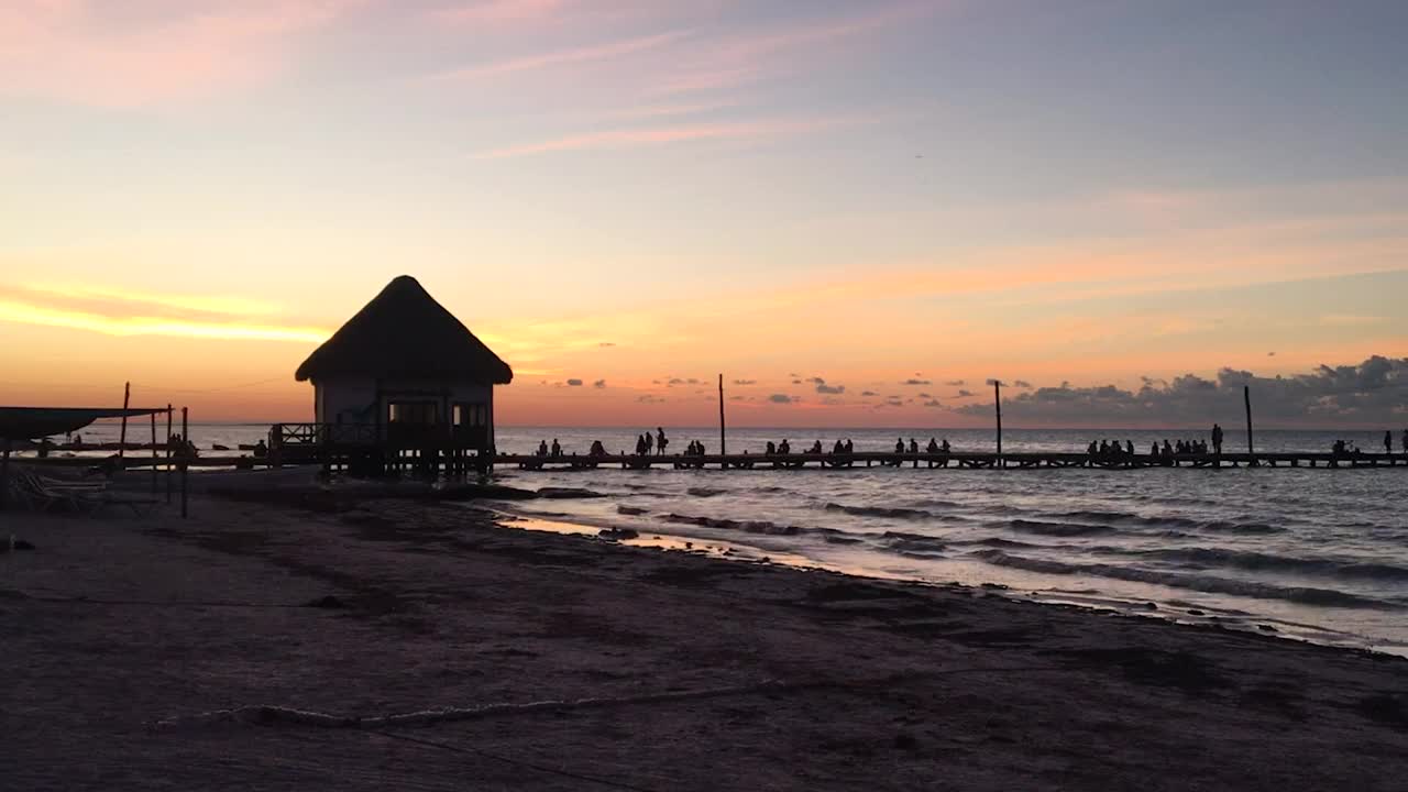 Tourists watching the sunset on a pier