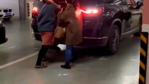 People blocking a parking spot get forcefully moved out of the way