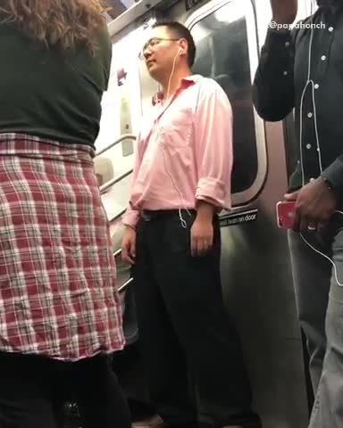 A man in a pink shirt dancing with head phones