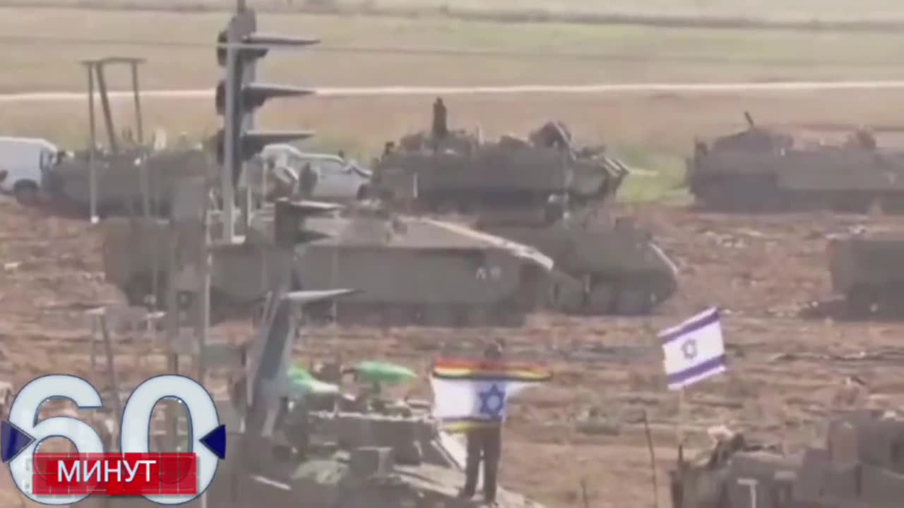 An IDF fighter waves an Israeli flag with an LGBT rainbow on it.