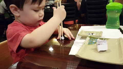 Kid Learning to Use Chopsticks