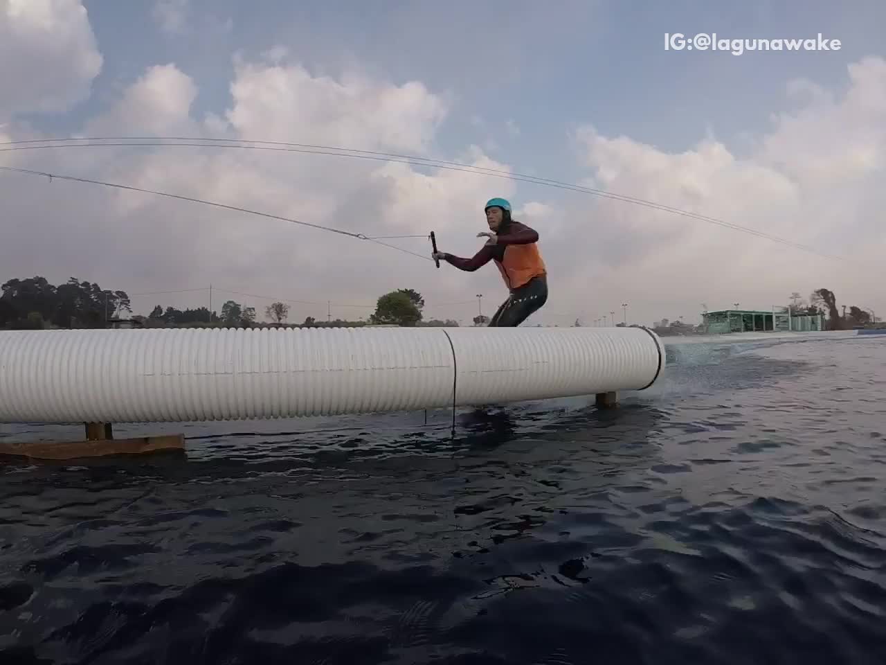 Guy wakeboarding tries to do trick but slams body into white pipe and falls into water