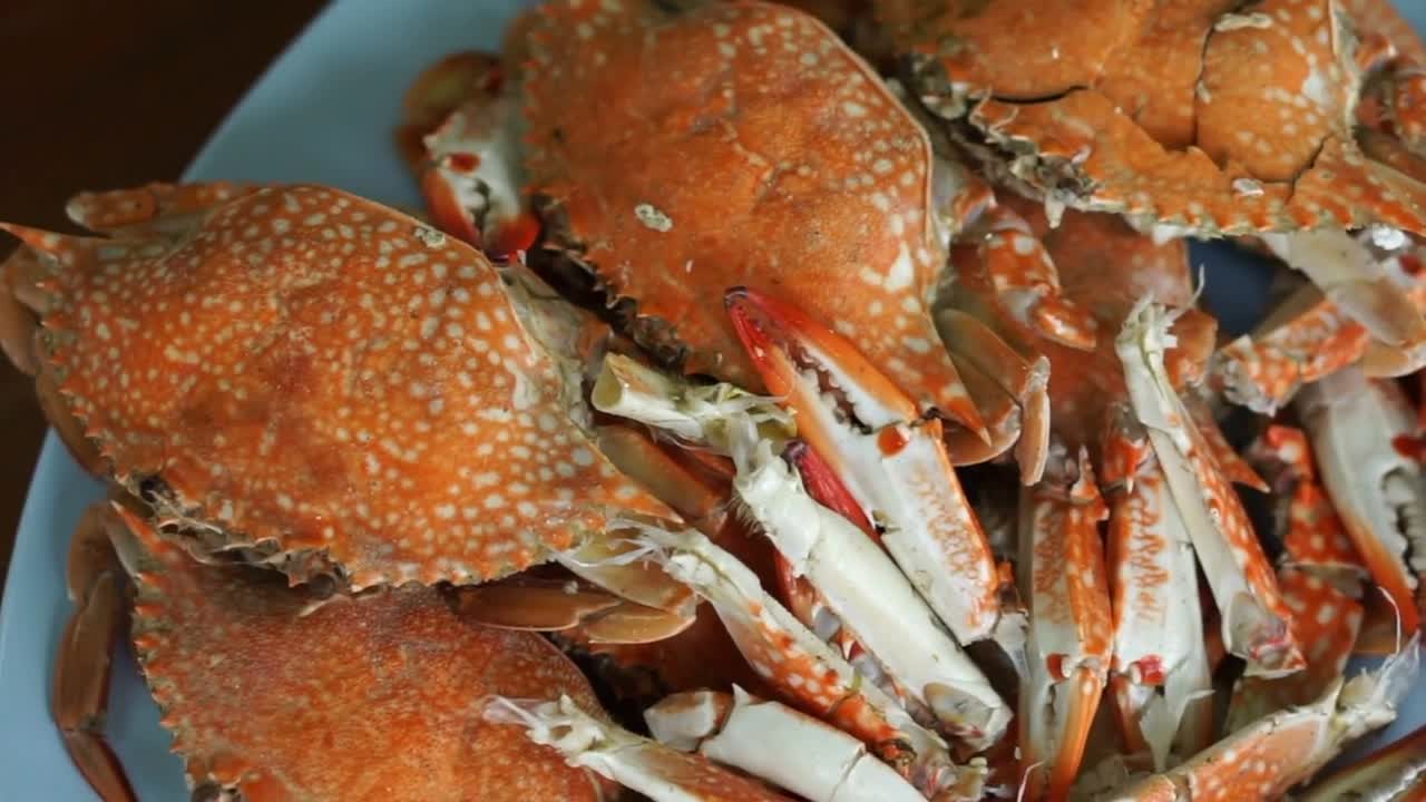 Thai seafood dish. Orange cooked steamed blue crabs on big plate