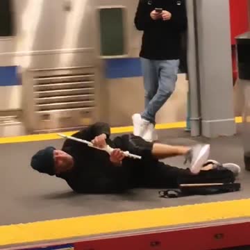 A man playing a flute on the ground