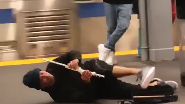 A man playing a flute on the ground