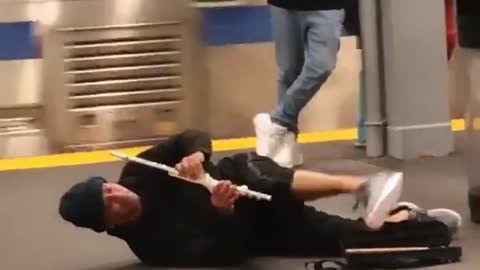 A man playing a flute on the ground