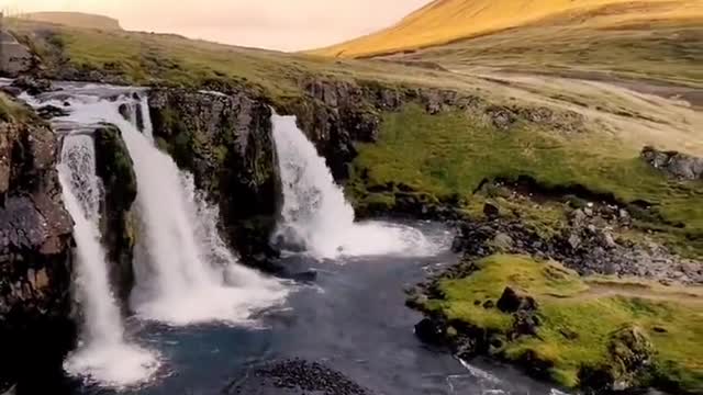 Kirkjufels waterfall in Iceland under a straw hat, beautiful sunset with a touch of sunset