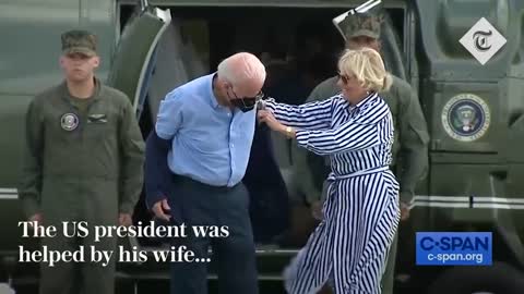 Joe Biden struggles to get his jacket on before dropping his sunglasses_1