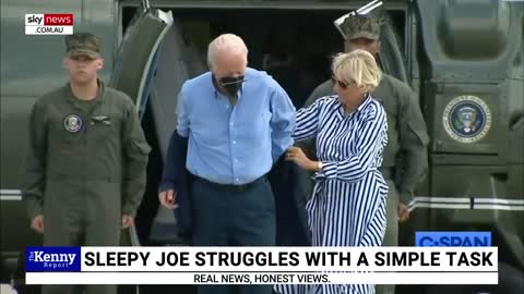 Joe Biden struggles to put on jacket amid 'very light breeze'