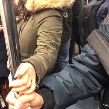 Man and woman hold onto handrail pole and touch hands